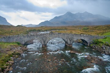 mountain river landscape with old bridge