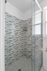 Light aqua blue and grey shower tile details with glass door.