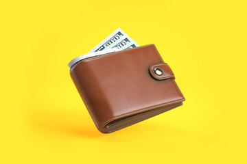 urse or wallet with money dollar bills on yellow background. - obrazy, fototapety, plakaty