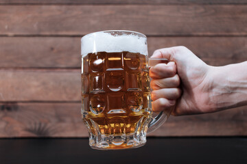 Hand holding glass of beer