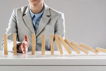 Business woman hand stop domino effect