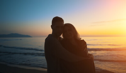 Attractive couple at sunset by the sea.