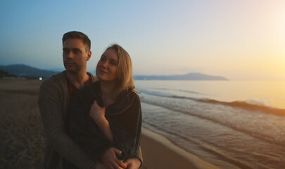 Attractive couple at sunset by the sea.