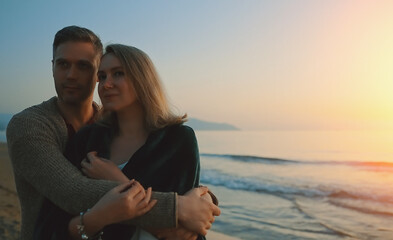 Attractive couple at sunset by the sea.