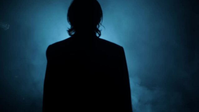 Shot of a young hitman in a blue colored coat with his gun resting on his shoulder HD footage.