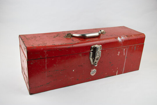 Old red retro handyman toolbox on white background