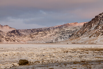 Beautiful landscape in Iceland in winter by a long and colorful sunrise with the mountains in the background.