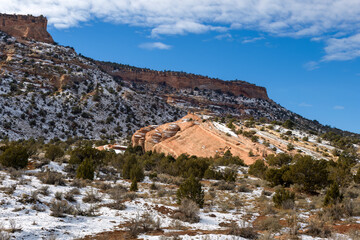 Fototapeta na wymiar Red rocks, part of a monocline at the base of the Colorado National Monument spotlit by the sun after a snowstorm