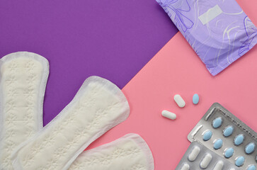 feminine hygiene pads and pills on colorful background