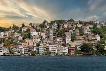 Fototapeta na wymiar View from the sea of the green mountains of the Europian side of Bosphorus strait, with traditional houses and dense trees in a summer day before sunset, Istanbul, Turkey