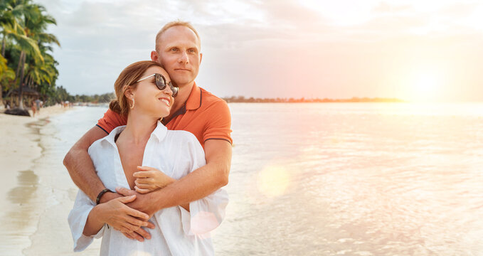 Couple in love hugging on the sandy exotic beach while they have a evening walk by the Trou-aux-Biches seashore on Mauritius island. People relationship and tropic honeymoon vacations concept image.