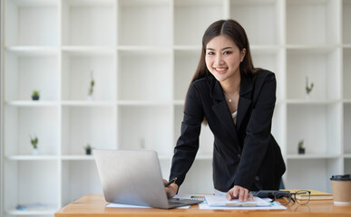 Beautiful Asian businesswoman crossed arms at the office looking at the camera.