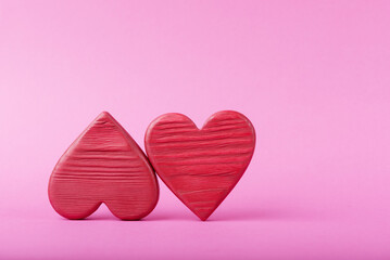 Two red wooden hearts over pink background with copy space. Valentine’s day greeting card mockup