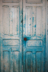 Old blue green closed weathered door in barrio santa cruz, alicante, spain