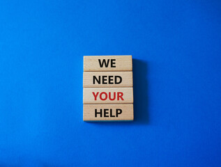 We need your help symbol. Wooden blocks with words We need your help. Beautiful blue background. Business and We need your help concept. Copy space.