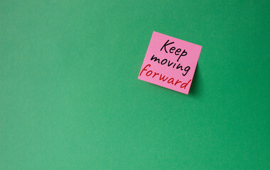 Keep moving forward symbol. Concept words keep moving forward on pink steaky note. Beautiful green background. Business and keep moving forward concept. Copy space.