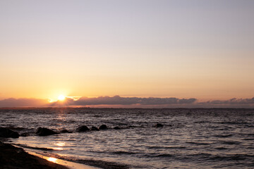 Scenic seascape with waves and sunrays at sunset.