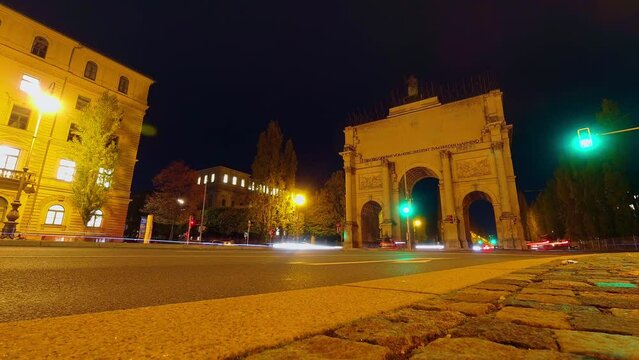 Low angle traffic speeding around Victory Arch Siegestor in central Munich, Germany.