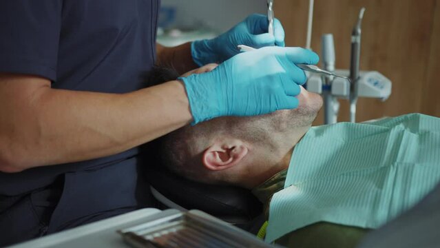 Patient sits in a dental chair. Dentist hold a dental instrument treats teeth. Hydience and health. Modern clinic