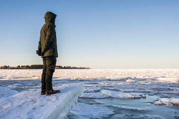 Man looking at the frozen sea. Monäs, Nykarleby/Uusikaarlepyy. Finland