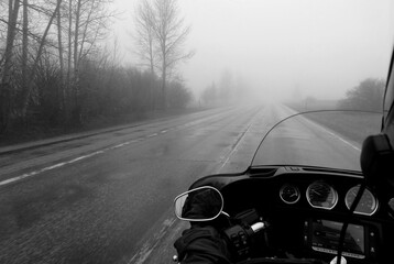 Harley Davidson Motorcycle driving in the fog on a roadway black and white