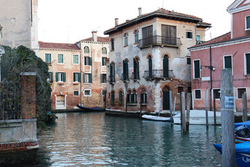 Colorful houses near water in the old medieval street in Venice, Italy. Street scene