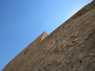Fototapeta na wymiar A castle wall with a contrast to blue sky
