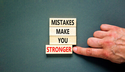 Mistake make stronger symbol. Concept words Mistakes make you stronger on wooden blocks. Beautiful grey table grey background. Businessman hand. Business mistake make stronger concept. Copy space.