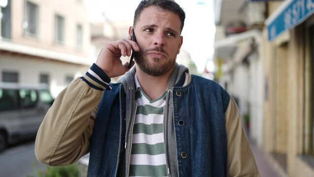 Young caucasian man speaking on the phone at street