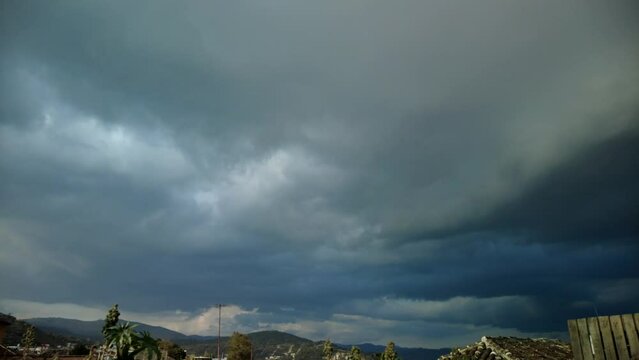 Formaci&oacute;n de tormenta, con nubes negras con fuerte lluvia sobre peque&ntilde;o pueblo en timelapse.