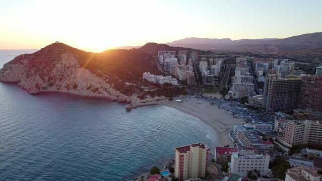 Finestrat beach at sunset with tall buildings. Tourist city in mediterranean sea.