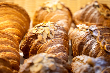 Fresh delicious buns and croissants with nuts are on the counter in the bakery. French croissants with pistachios and hazelnuts top view. Homemade cakes.