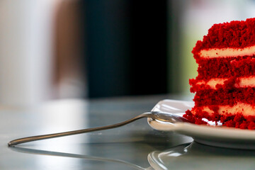 A piece of delicious cake on a plate on the table. Fresh pastries and confectionery in the store.