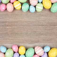 Colorful pastel Easter egg double border. Above view on a square, light wood background. Copy space. - 570696600