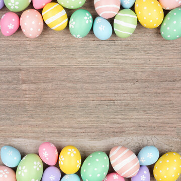 Colorful pastel Easter egg double border. Above view on a square, light wood background. Copy space.