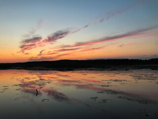 Sunset on the lake is reflected in the water at dusk. Tourism and travel concept.