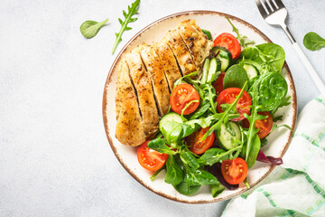 Healthy food plate. Green salad with chicken fillet on white. Top view with copy space.