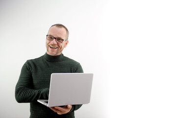 middle-aged man balding in glasses holding laptop joyful fun he shows his feelings to others he is a professor in a dark green golf radiates vibes of joy to students a lecture for lectures with laptop