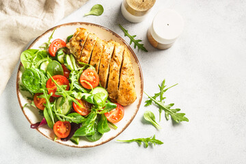 Green salad with chicken fillet on white. Healthy food. Top view with copy space.
