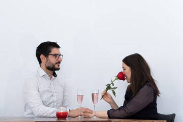 young woman smells a rose given to her by her husband