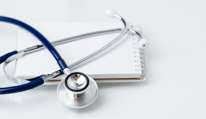 Stethoscope on white notepad with copy space.