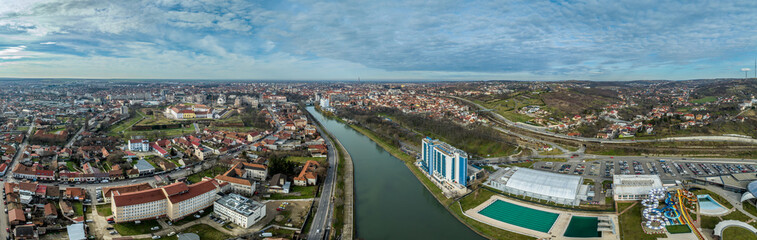 Aerial panoramic view of Oradea Nagyvarad on the Crișul Repede river with medieval pentagonal fortress, secessionist building in downtown, synagogue tower, waterpark