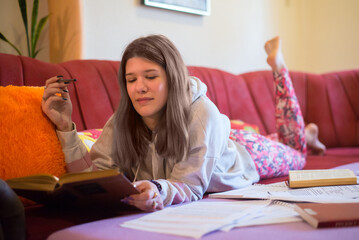 Young smiling woman student studying for exams at home
