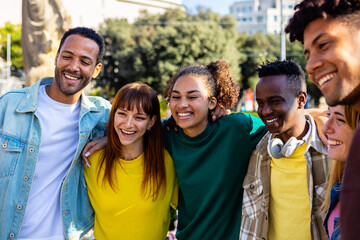 United multiracial young group of college student friends standing together outdoor. Diverse multi-ethnic happy people smiling while embracing each other in the city