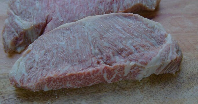 Japanese A5 Wagyu Steak is Being Prepared to Grill putting Salt and Pepper
