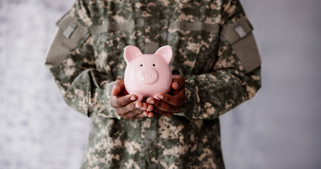 Soldier's Hand Holding Pink Piggy Bank