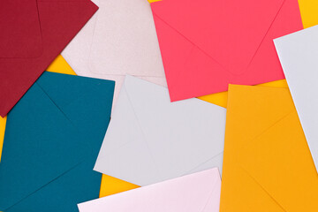 Multicolored envelopes scattered on a yellow background. Creative background.