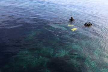 May 24, 2017 - Tuscany, Italy: two divers swimming on the surface of the water with the equipment