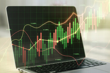Multi exposure of abstract financial graph on laptop background, financial and trading concept