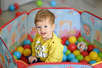 Fototapeta na wymiar Cute kid or child playing colorful balls. Activity toys for little kid.